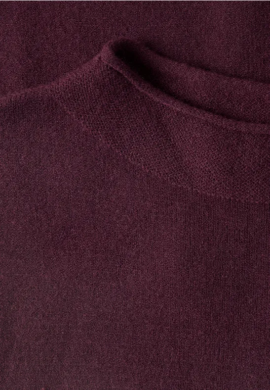 Nahaufnahme eines bordeauxroten Strickpullovers mit Rundhalsausschnitt.