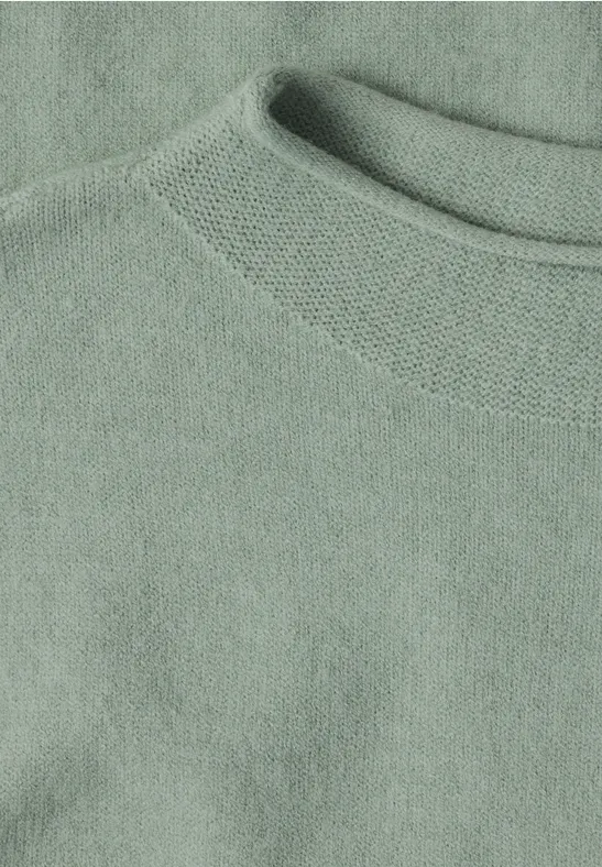 Nahaufnahme eines hellgrünen Pullovers/Sweatshirts mit rundem Halsausschnitt aus weichem Stoff.