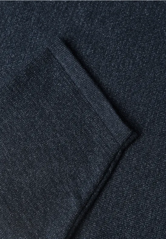 Nahaufnahme eines dunklen Jeansstoffs mit deutlich sichtbarer Falte.