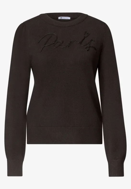 Schwarzer Pullover mit langen Ärmeln und dezentem Logo-Stick auf der Brust.