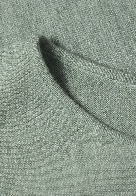 Close-up van de ronde hals van een groen-grijs T-shirt van zachte stof.