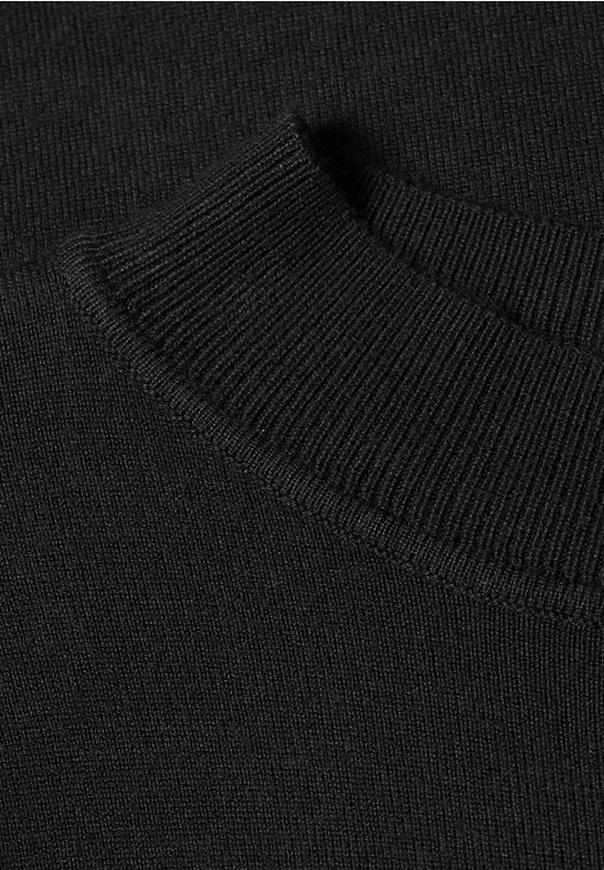 Nahaufnahme eines schwarzen Pulloverkragens aus feiner Strickware.