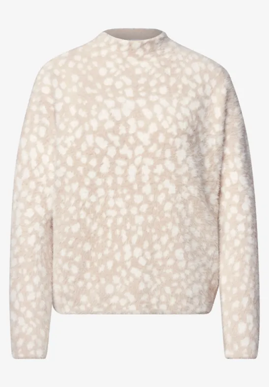 Beiger Pullover mit rundem Ausschnitt und zartem weißem Fleckenmuster.