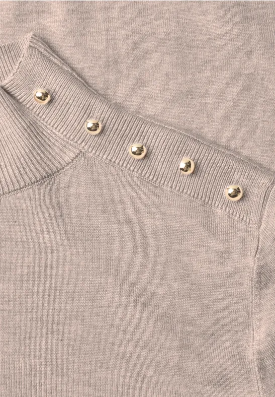 Beiges Strickoberteil mit Rippenmuster und einer Reihe goldener Knöpfe an der Schulter