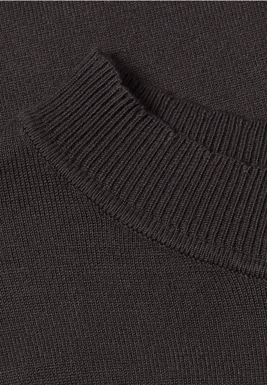 Nahaufnahme eines schwarzen, fein gestrickten Pullovers mit geripptem Kragen.