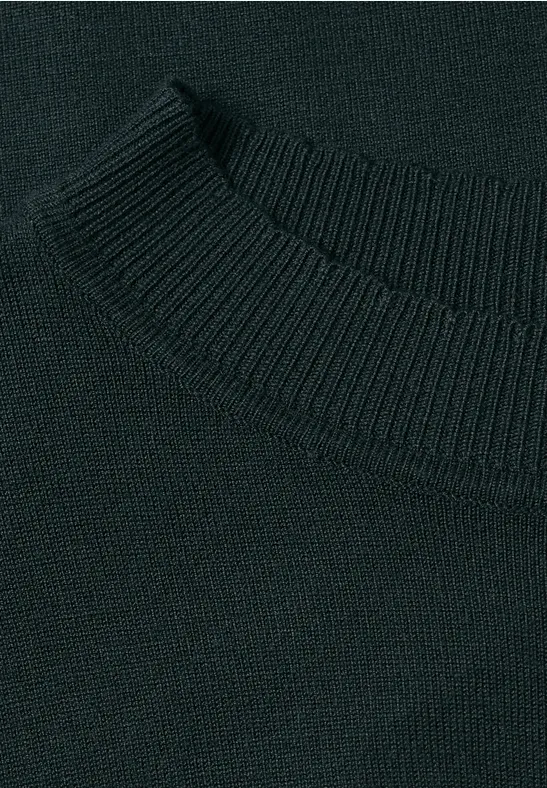 Nahaufnahme eines dunkelgrünen, feinstrickten Pulloverkragens.