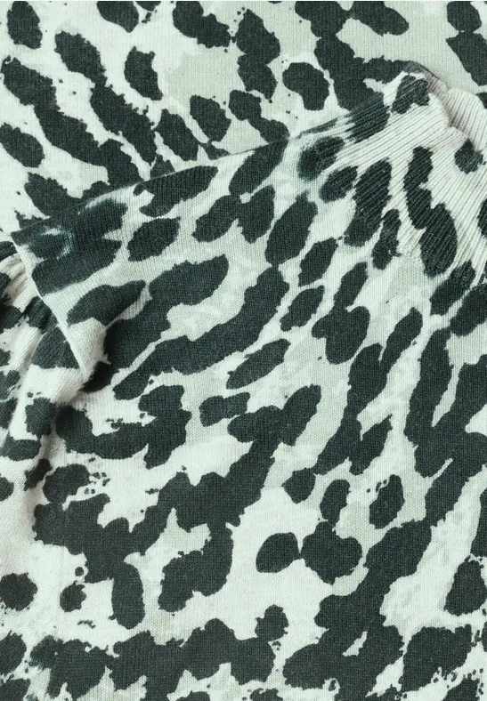 Close-up van een textiel met onregelmatige zwart-witte vlekken in dierenprintstijl
