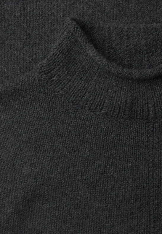 Schwarzer Rollkragenpullover aus grobem Strick.