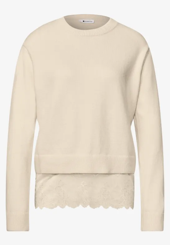 Beiger Strickpullover mit runder Kragen und spitzenbesetztem Saum.