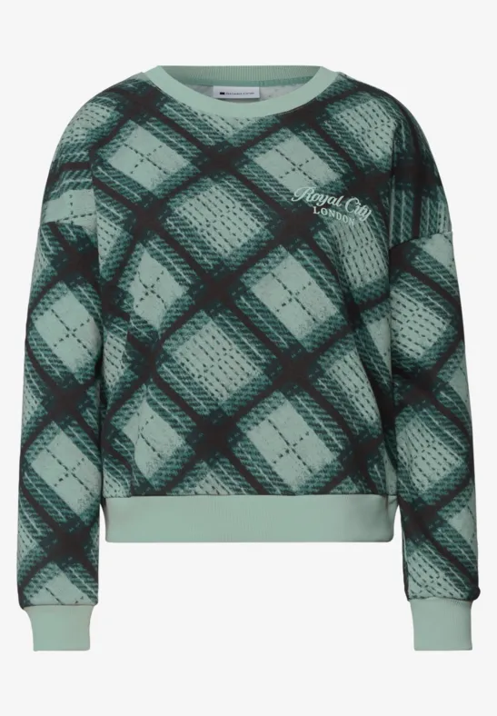 Sweat vert à carreaux noirs, manches longues et finitions côtelées.