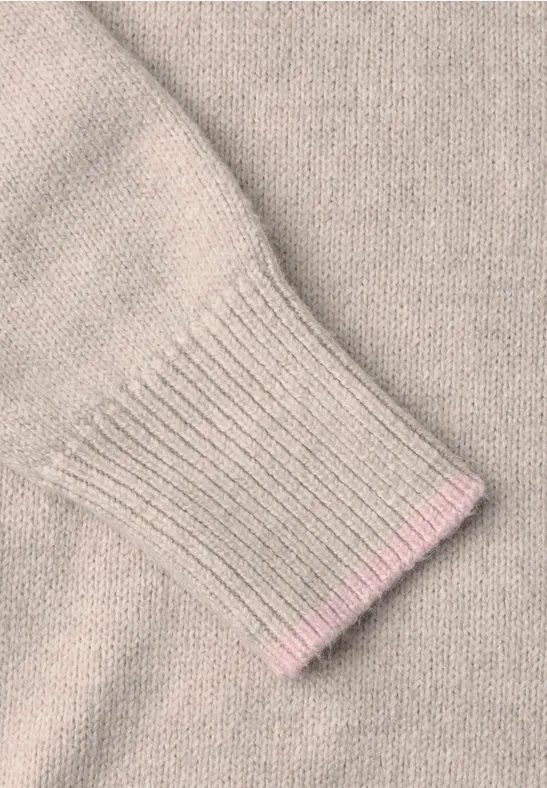 Beige Pulloverärmel mit feinem Strickmuster und rosa Abschluss