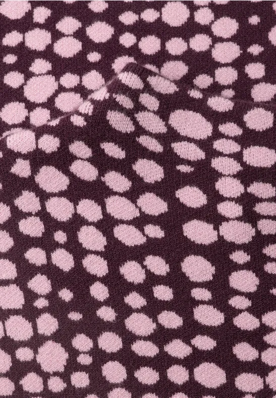 Lila Stoff mit unregelmäßigen rosa Punkten.