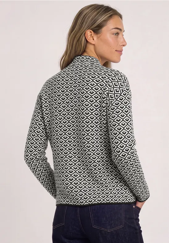 Frau in schwarz-weiß gemustertem Strickpullover mit Stehkragen, Rückansicht leicht seitlich.