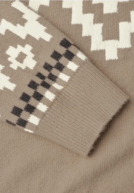 Nahaufnahme eines beigen Strickpullovers mit weißem und dunkelbraunem geometrischem Muster.