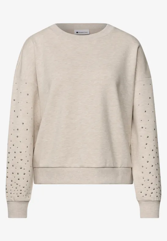 Pull léger beige à col rond, manches ajourées de petits trous.