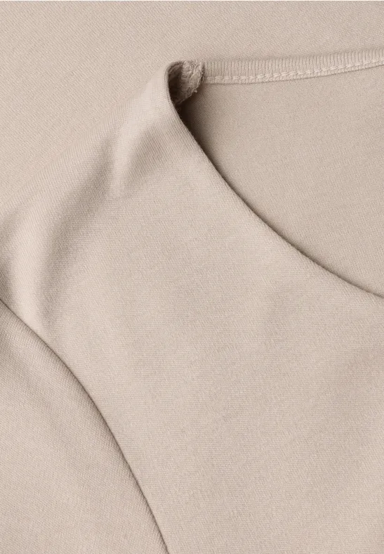 Beige ärmelloses Oberteil aus weichem Stoff, Nahaufnahme der texturierten Baumwolloptik.