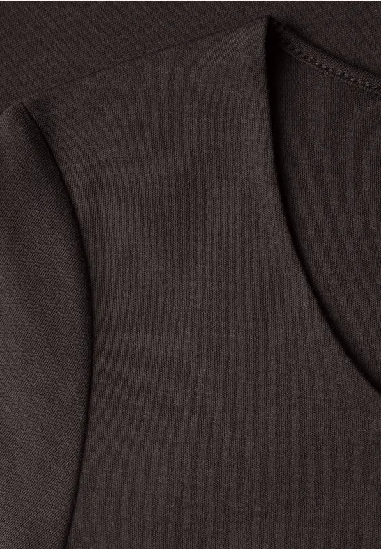 Nahaufnahme eines braunen T-Shirts mit sichtbarer Naht und rundem Ausschnitt.