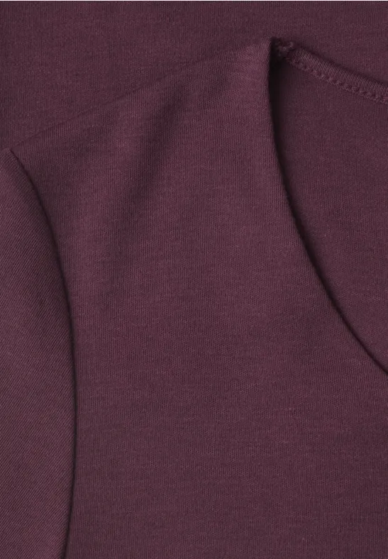 Gros plan sur un tissu de sweat-shirt bordeaux avec coutures apparentes