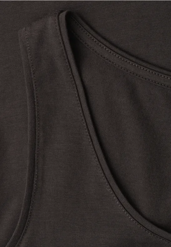 Close-up van een zwart hemdje met ronde hals en fijne stiknaden.