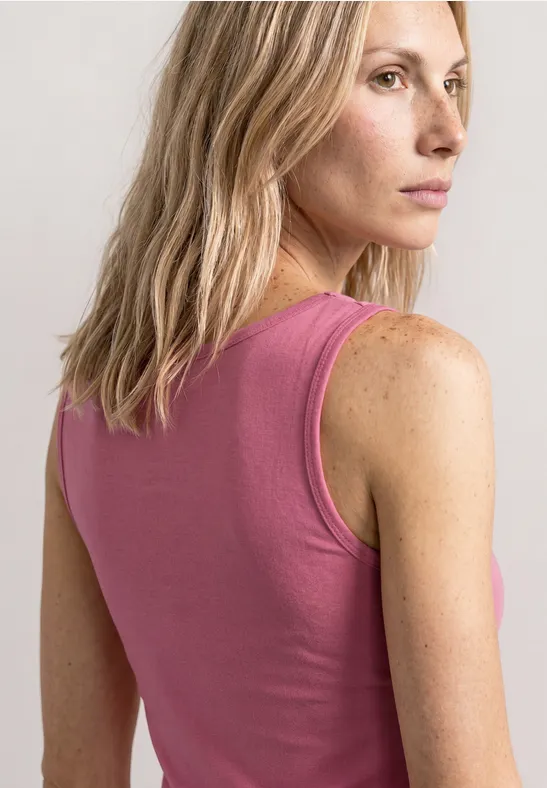 Vrouw met blond haar van achteren in een mouwloze roze top