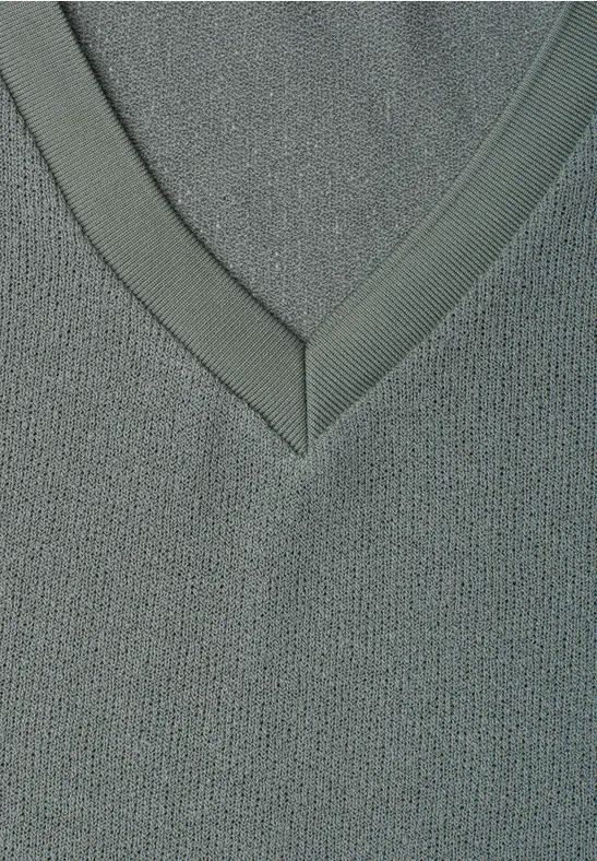 Close-up van een grijze V-hals van fijne gebreide stof met subtiele structuur.