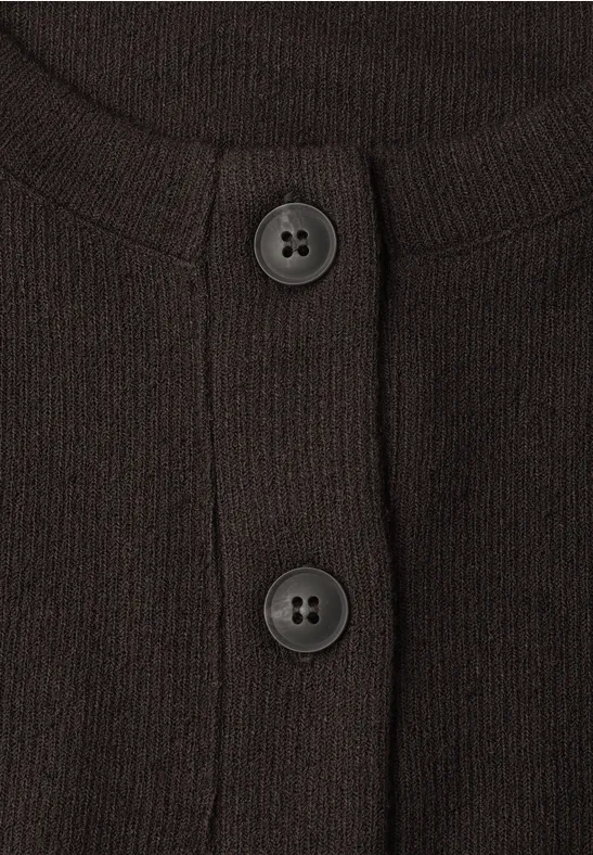 Gros plan d'un gilet sombre en maille avec deux boutons