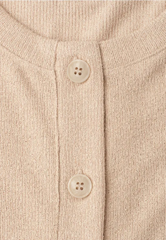 Beige gebreid vest met ronde hals en twee knopen.