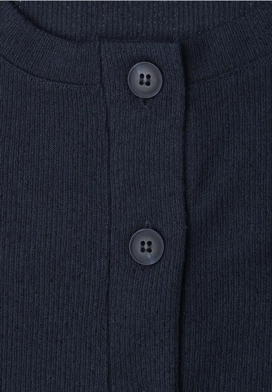 Nahaufnahme eines dunkelblauen, gerippten Oberteils mit Rundhalsausschnitt und zwei Knöpfen.