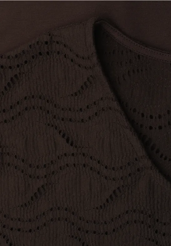 Close-up van een donkerbruin gebreide stof met een golvend open patroon.