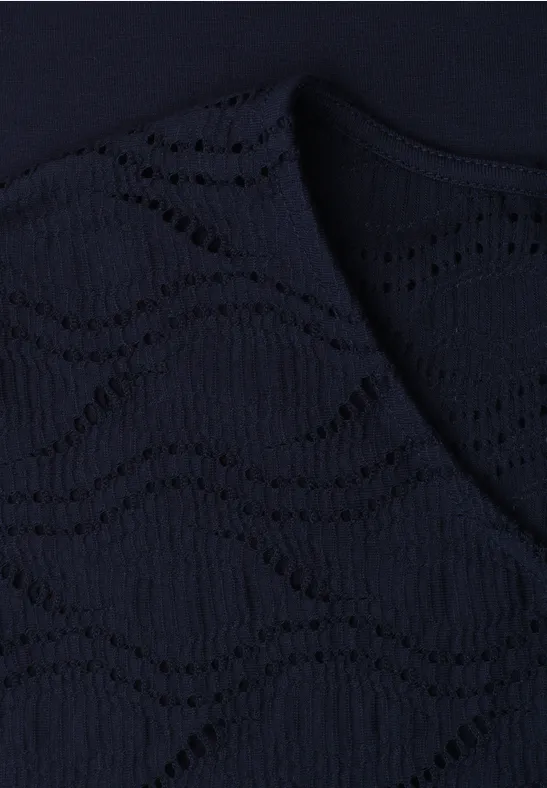 Donkerblauwe gebreide stof met golvend ajourpatroon.