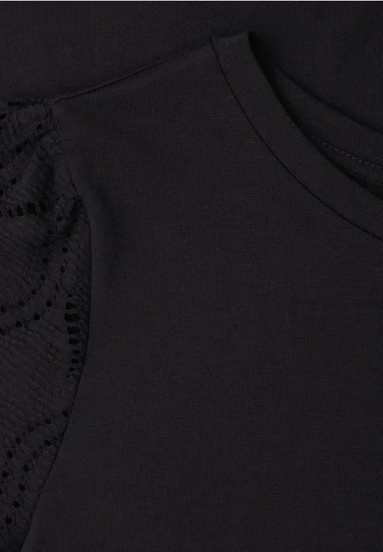 Zwart T-shirt met kanten inzet op de schouder.