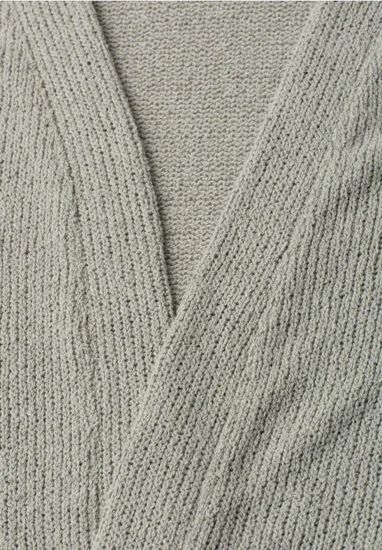 Gros plan d'un gilet gris en maille au col en V croisé.