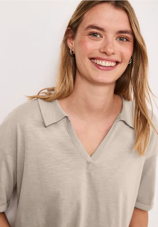 Vrouw met een beige korte mouw T-shirt met V-hals.