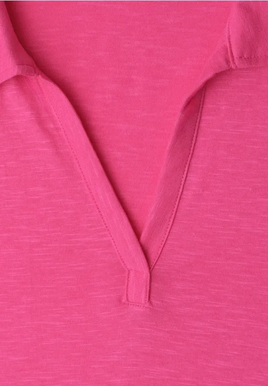 Close-up van een roze fuchsia T-shirt met kraag en V-hals