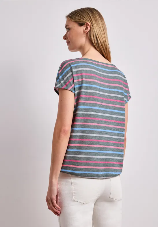 Vrouw in zijaanzicht met kleurrijk gestreept t-shirt, op een lichte, neutrale achtergrond.