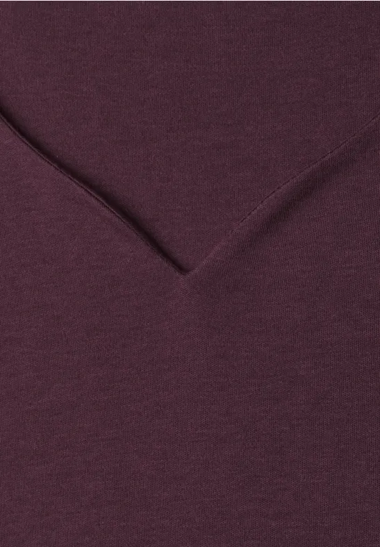 Nahaufnahme eines weinroten V-Ausschnitt-Shirts aus weichem Stoff