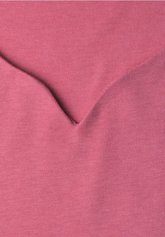 Nahaufnahme eines rosa Stoffes mit V-förmiger Naht.