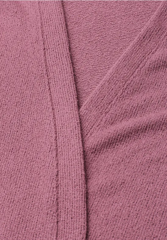 Gros plan sur un tissu texturé rose avec couture