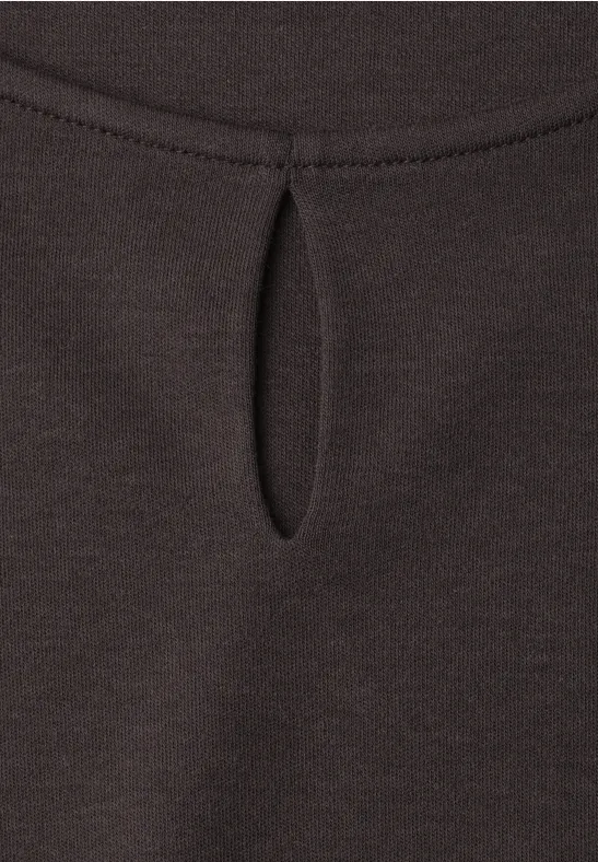 Donkerbruin shirt van zachte stof met een kleine druppelvormige opening bij de hals.