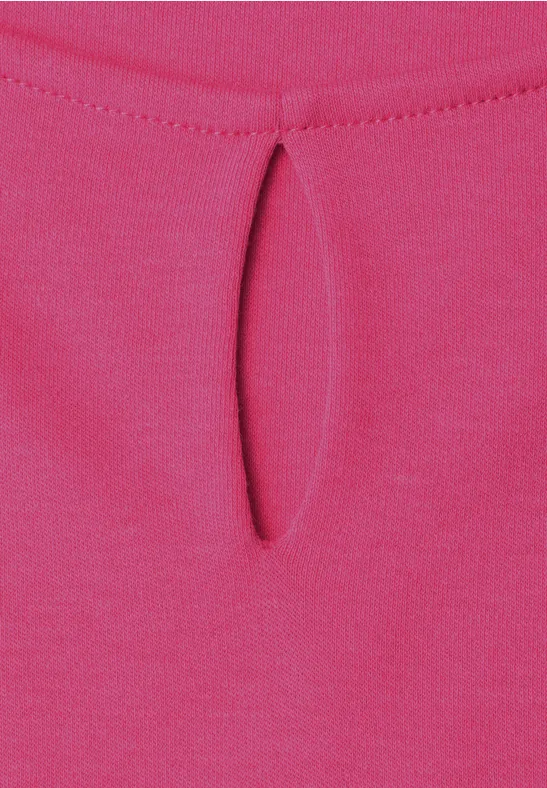 Nahaufnahme eines pinken Stoffes mit kleinem Tropfenausschnitt am Kragen