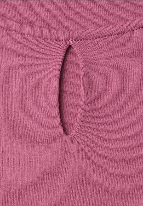Roze top met een kleine druppelvormige uitsnijding bij de halslijn.