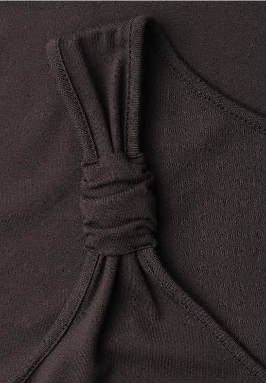 Schwarzes Top mit schmalem Träger und dekorativem Knoten im elastischen Stoff.