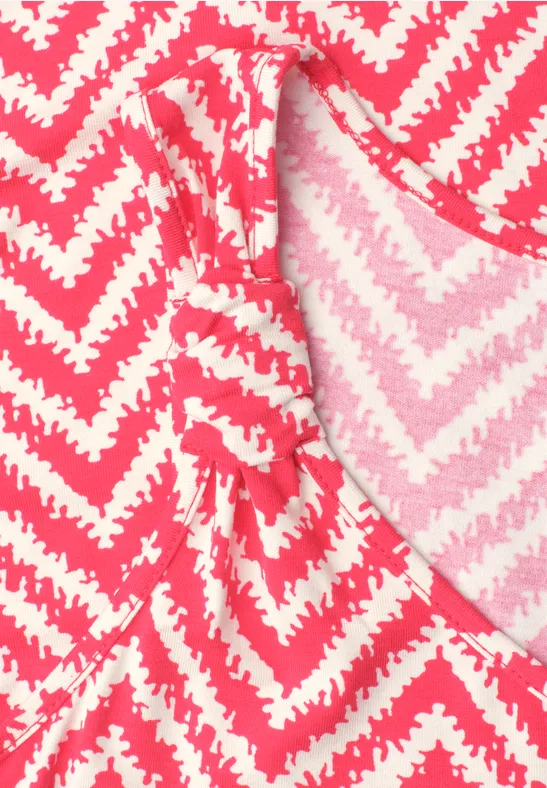 Nahaufnahme eines pink-weißen Zickzack-Musters auf einem Kleidungsstück