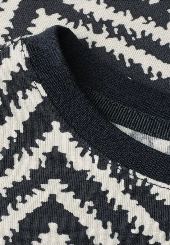Schwarz-weiß gemustertes Textil mit Zebrastreifen-Design und Rundhalsausschnitt.