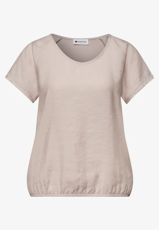 T-shirt femme beige clair à manches courtes, encolure ronde et bas élastiqué pour un style décontracté.