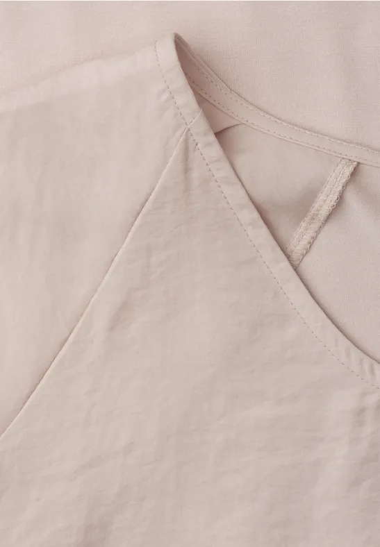 Gros plan sur un haut en lin rose pâle avec encolure en V