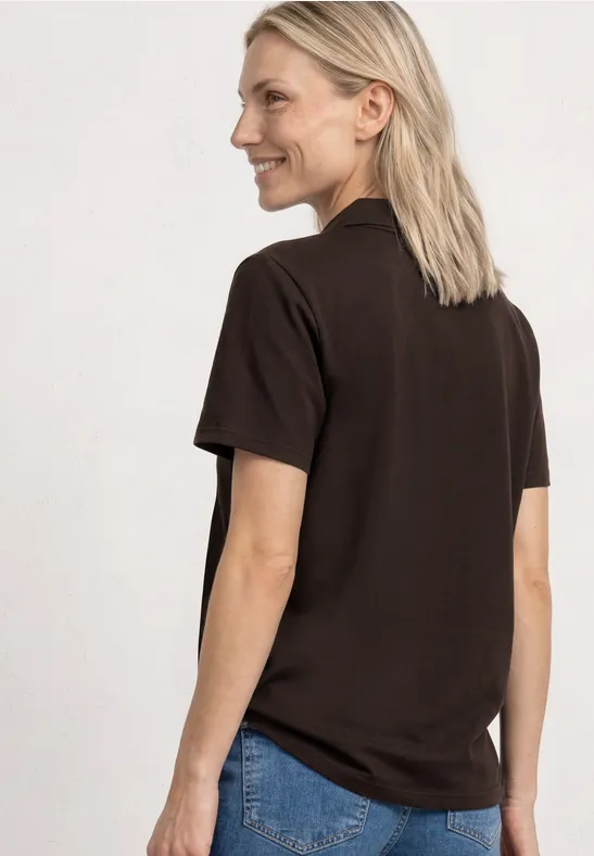 Frau von hinten im braunen T-Shirt und Jeans