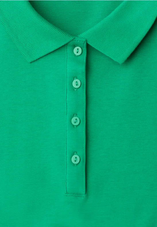Close-up van een groen poloshirt met knoopsluiting en bijpassende knopen