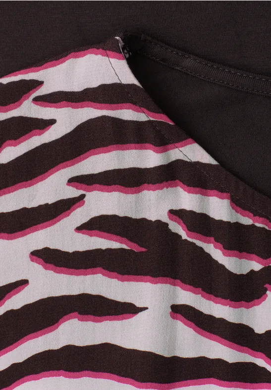 Close-up van stof met bruin-wit zebraprint en roze accenten.
