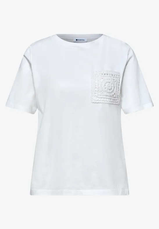 Witte T-shirt met ronde hals en een borstzakje versierd met gehaakte kant.